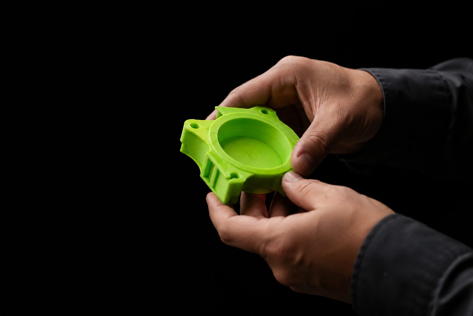 Mãos segurando uma peça recém-impressa em 3D